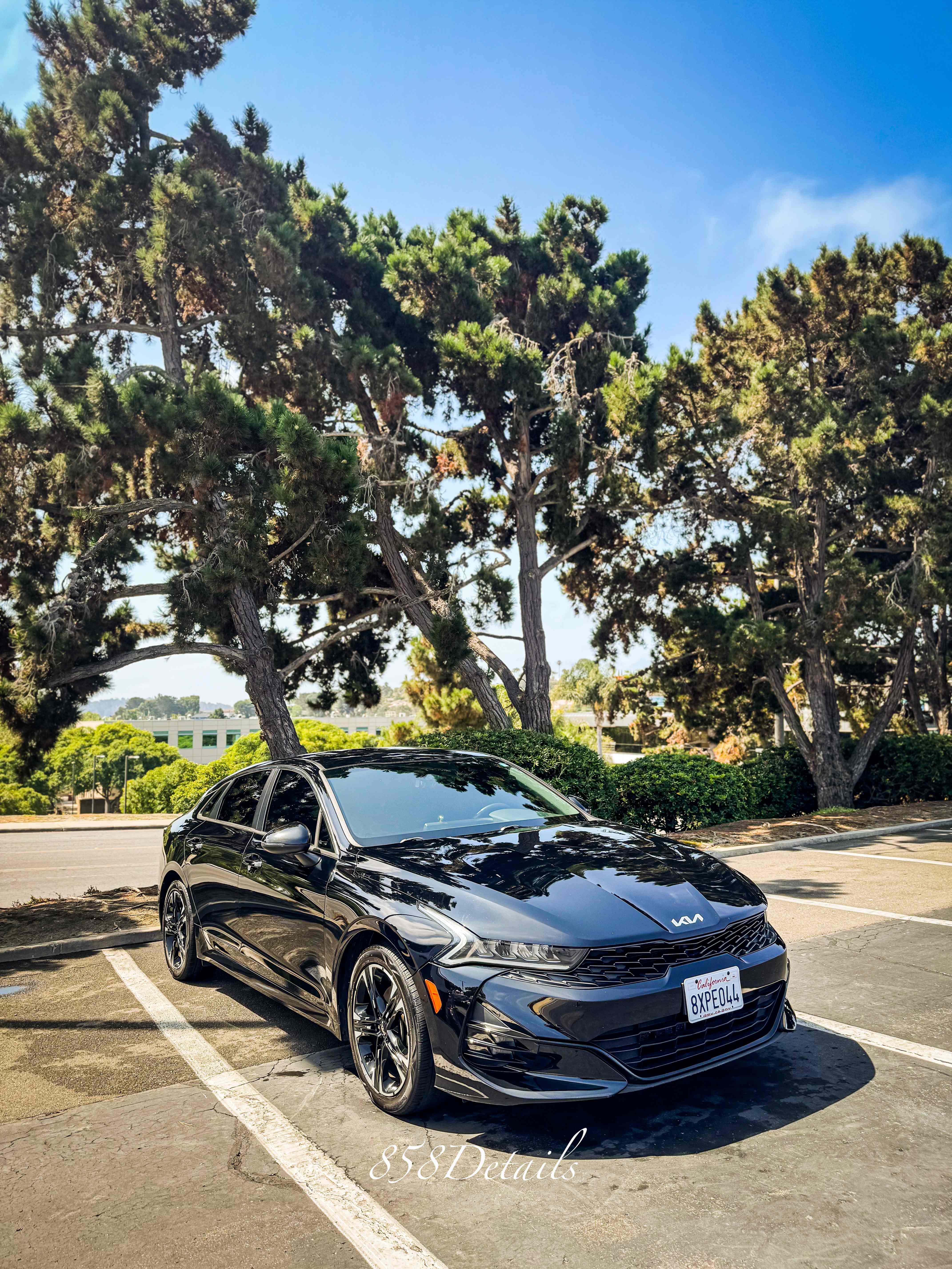 Black Kia sedan with mirror-like finish after ceramic coating